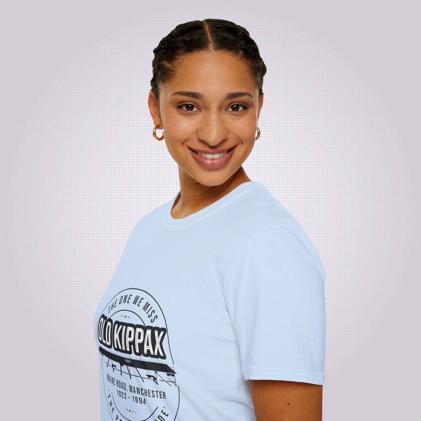 Side profile picture which features an attractive young mixed race girl in her twenties, she is wearing the light blue t shirt and although her body is facing to the left she has turned her head to face the camera and is smiling.