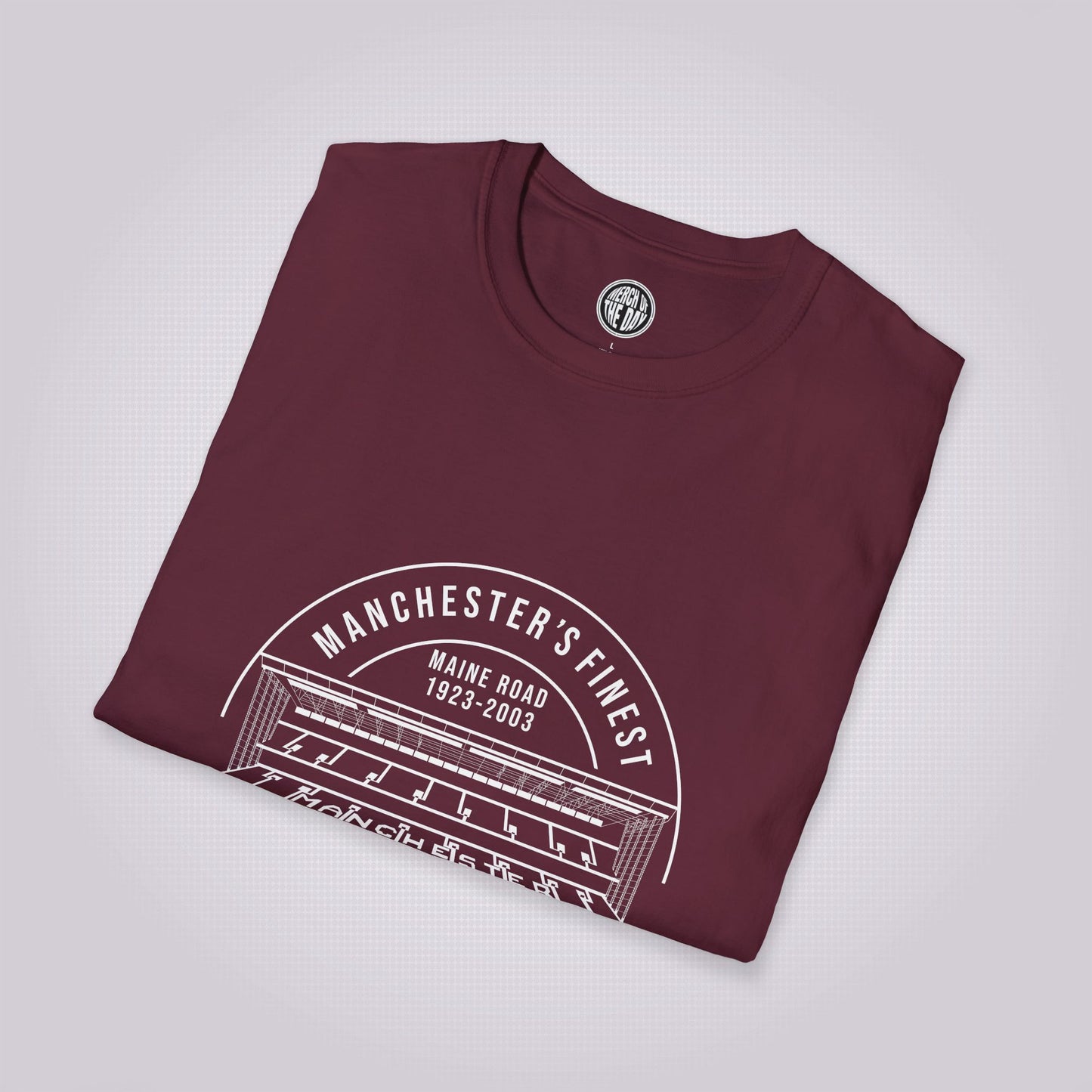 Maroon t shirt placed at a slight right angle on a light grey dotted background