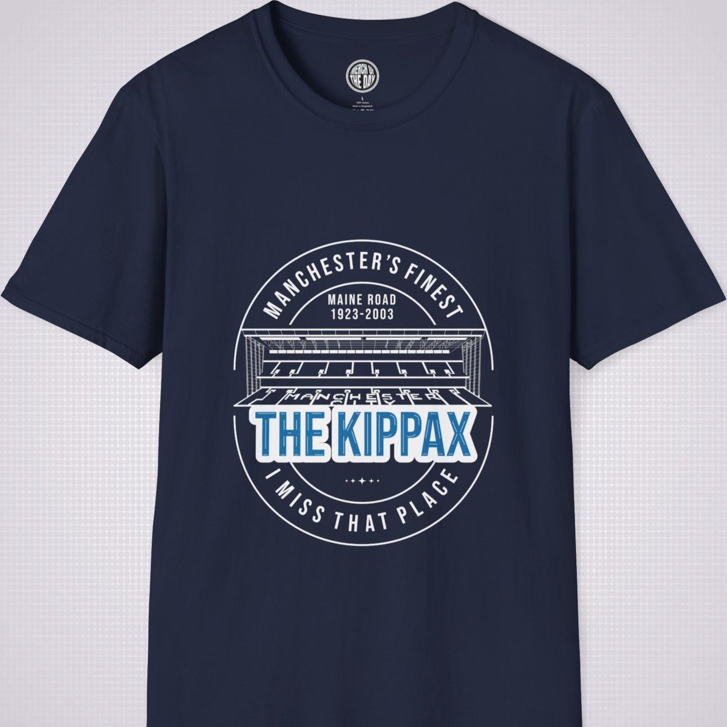 Navy T Shirt on a light grey dotted background. There is an illustration of the Kippax Stand, above the illustration it reads 'Manchester's Finest Maine Road 1923 to 2003'. Below the illustration it reads 'The Kippax I miss that place'