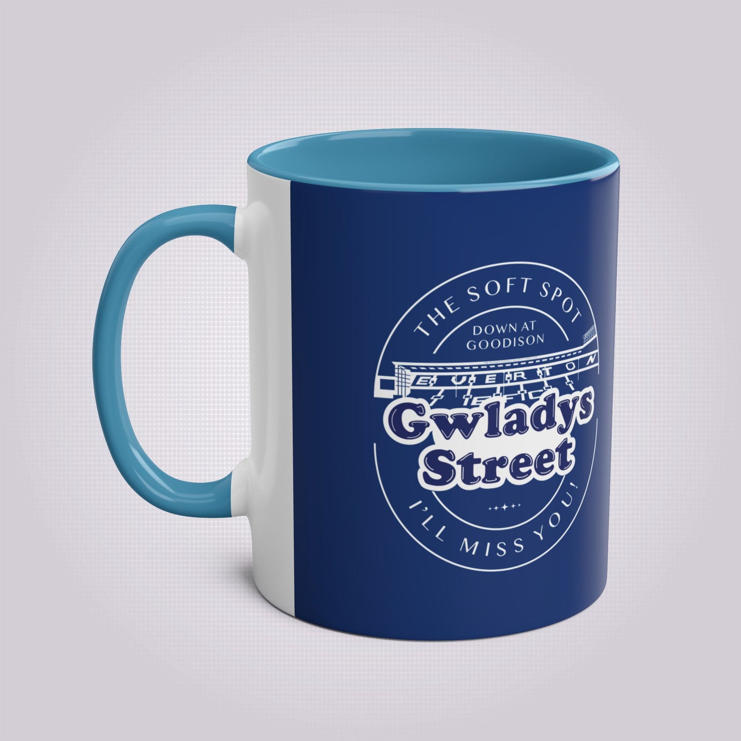 This shows another shot of the navy blue and light blue mug on a light grey patterned background with the handle on the left hand side of the image.