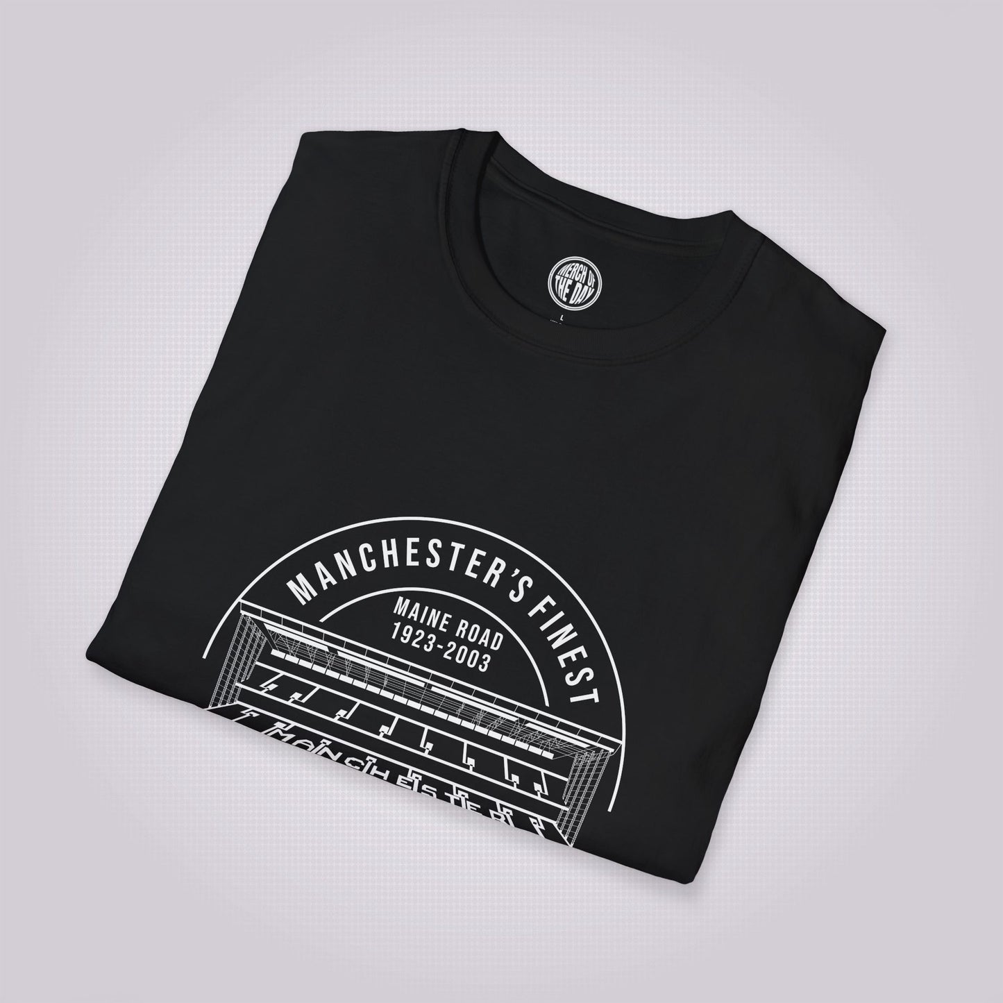 Black T Shirt folded up and placed at a slight right angle on a light grey dotted background