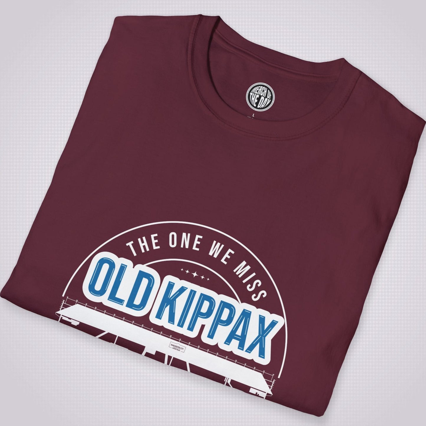 Maroon T Shirt folded and placed at a slight angle on a light grey dotted background