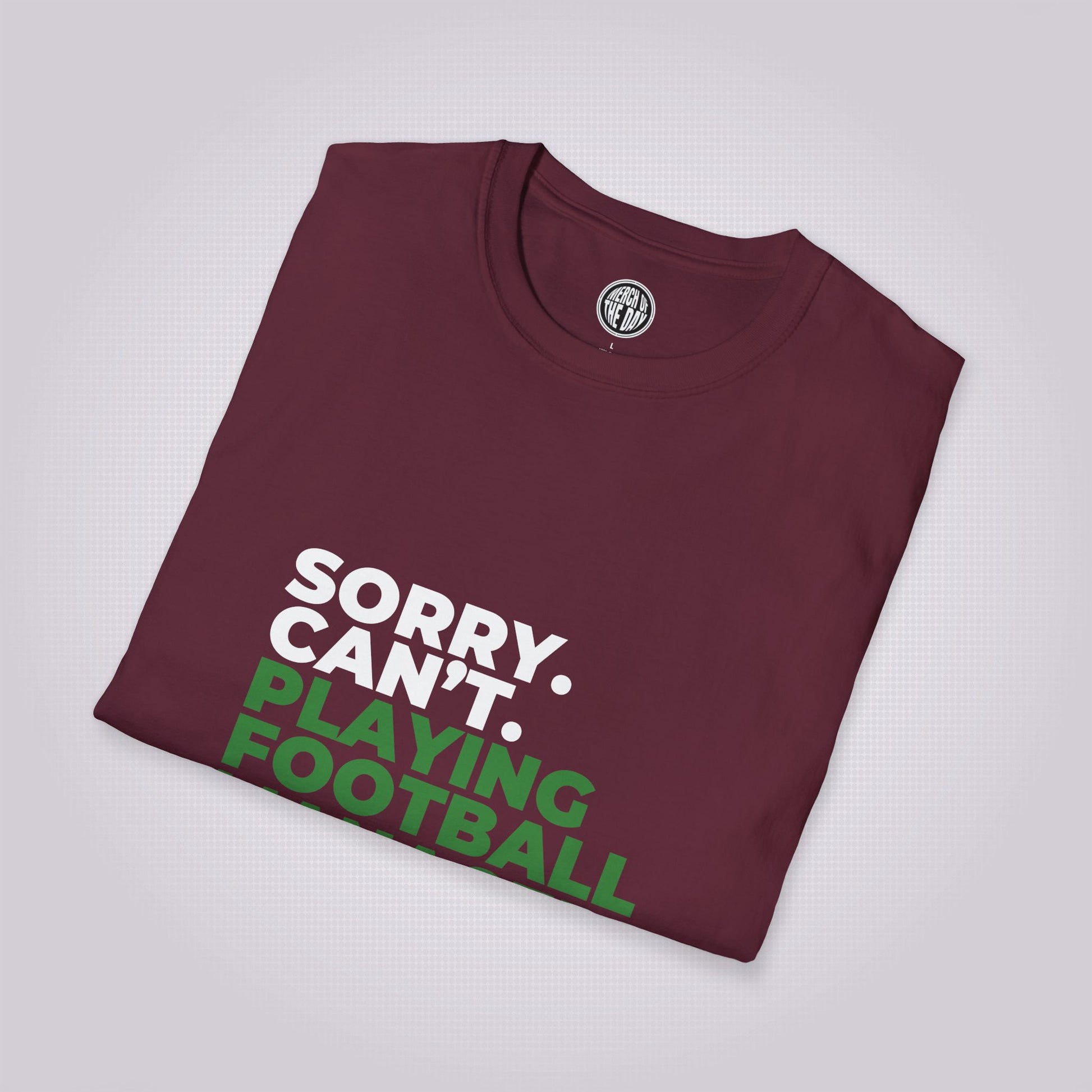 Maroon t shirt folded up and placed at a right angle showing the top part of the shirt graphic