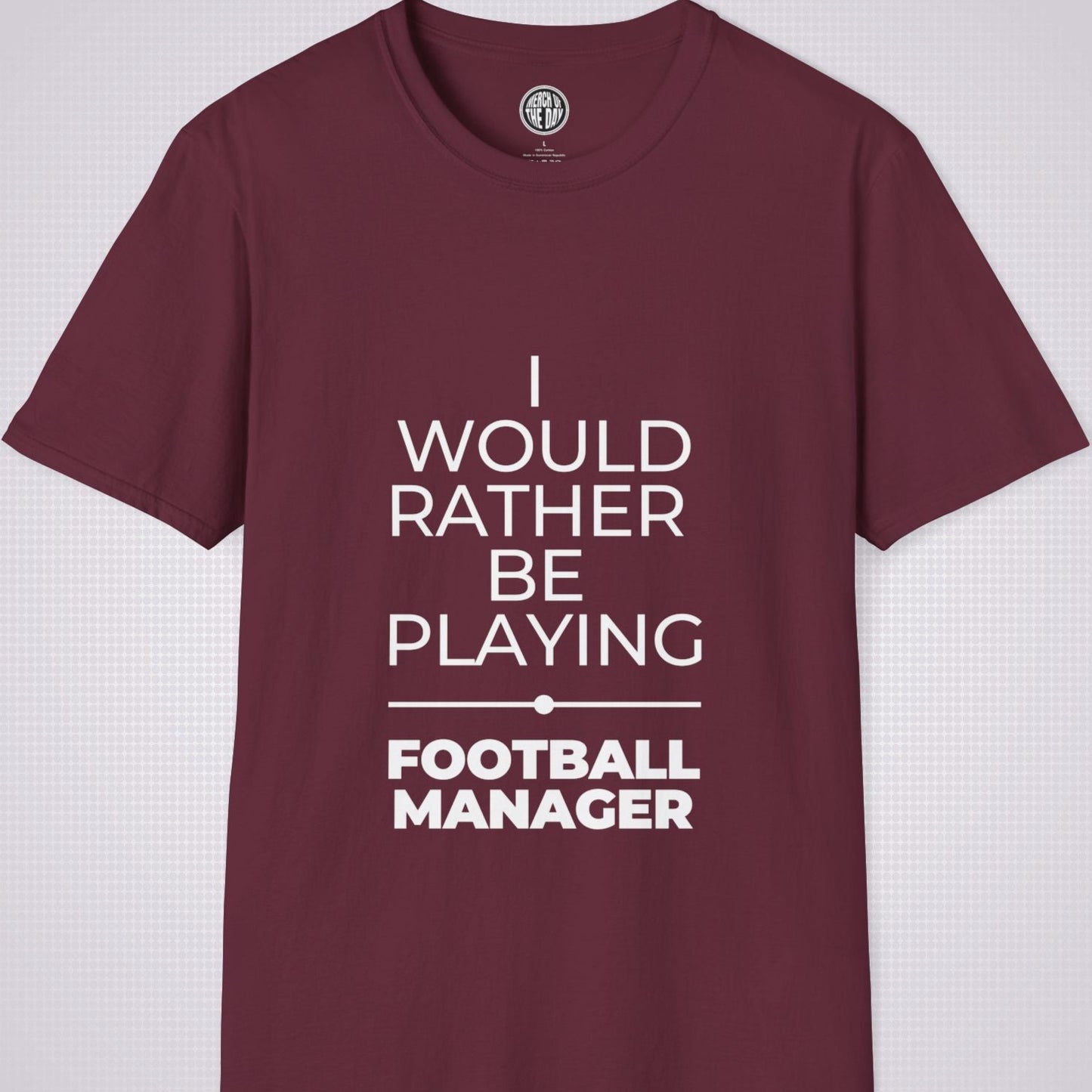 Maroon t shirt on a light grey patterned backdrop with text on the shirt saying I would rather be playing football manager