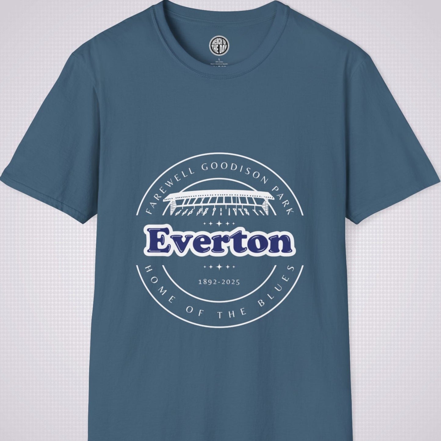 Indigo blue t shirt on a light grey dotted background there is a graphic showing an illustration of the main stand at Goodison Park with the words 'Farewell Goodison Park' written in a downward facing arc above it, below it are the  words 'Everton 1892 to 2025' and then below that are the words 'Home of the blues' written in an upward facing arc