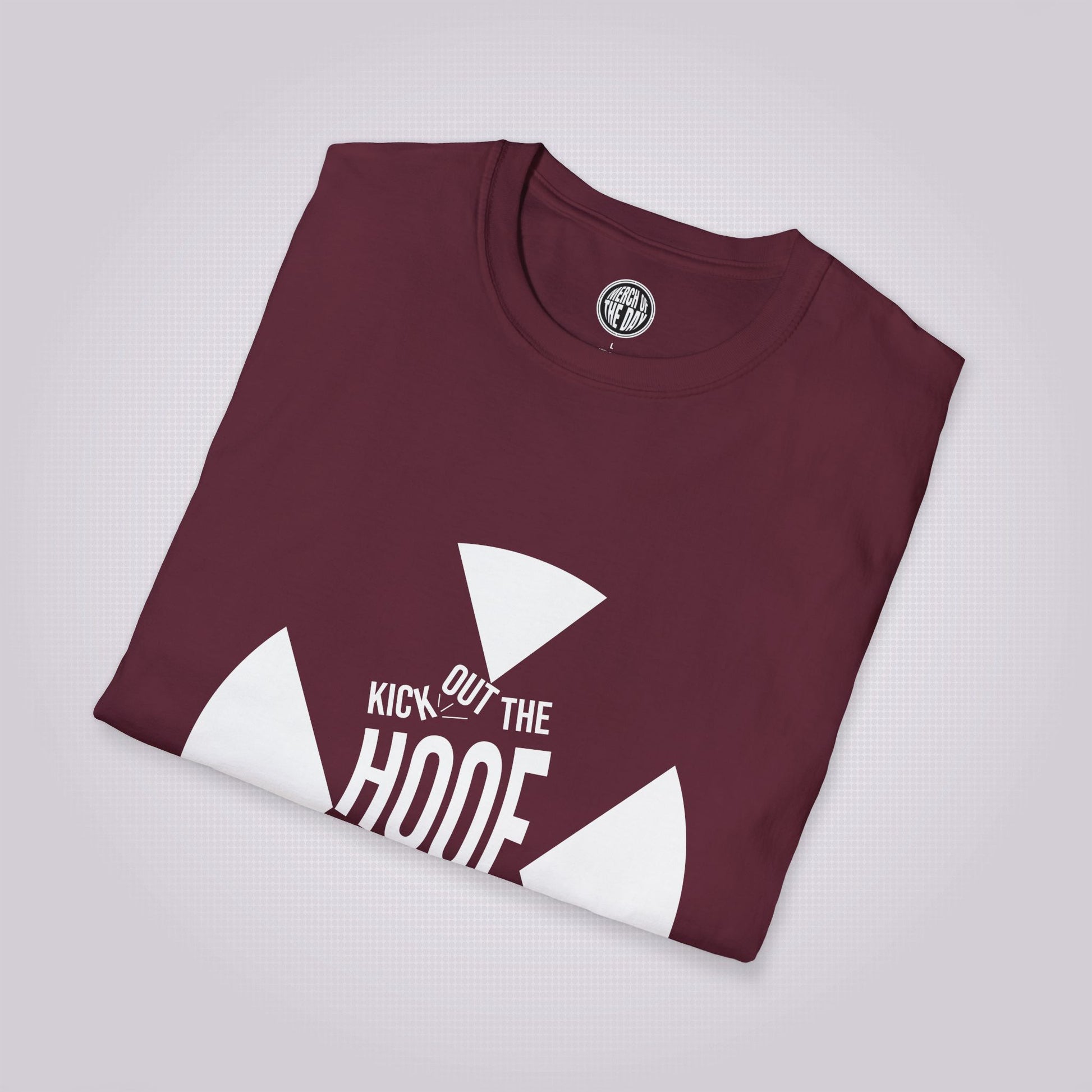 Maroon T Shirt folded up and placed at a slight right angle on a light grey dotted background