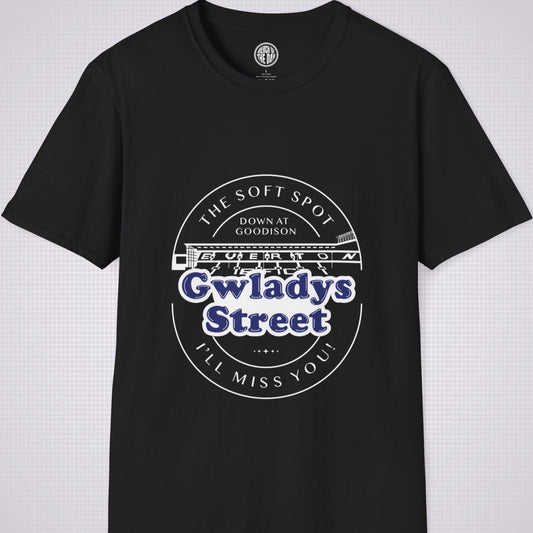 Black t shirt on a light grey dotted background. There is an illustration of the Gwladys Street End which has the following words above it in a downward arc 'The Soft spot', then underneath that it reads 'Down At Goodison'. Then below the illustration it reads 'Gwladys Street' in Navy blue lettering with a white fill behind it to make it stand out. Underneath that it says 'I'll Miss You' in a upward facing arc.