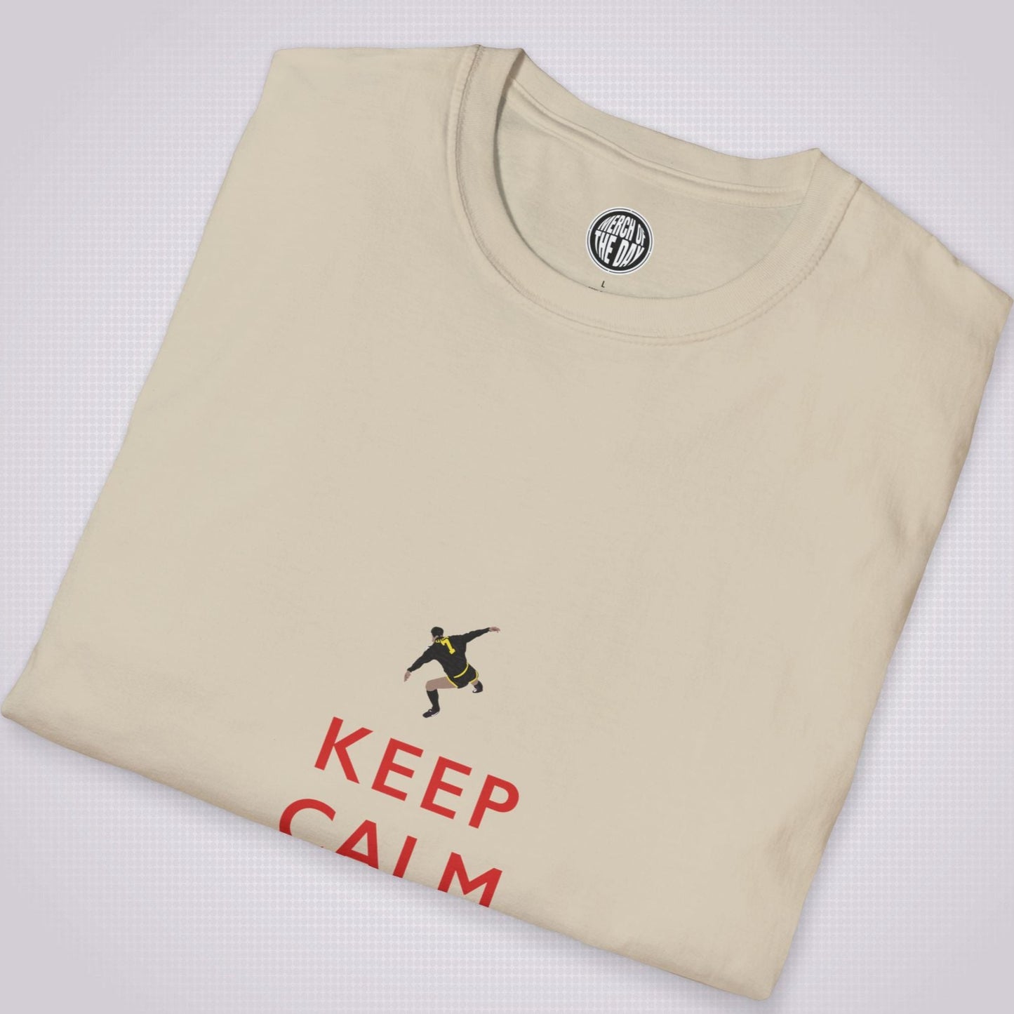 Sand t shirt folded up and placed at a slight right angle on a light grey dotted background