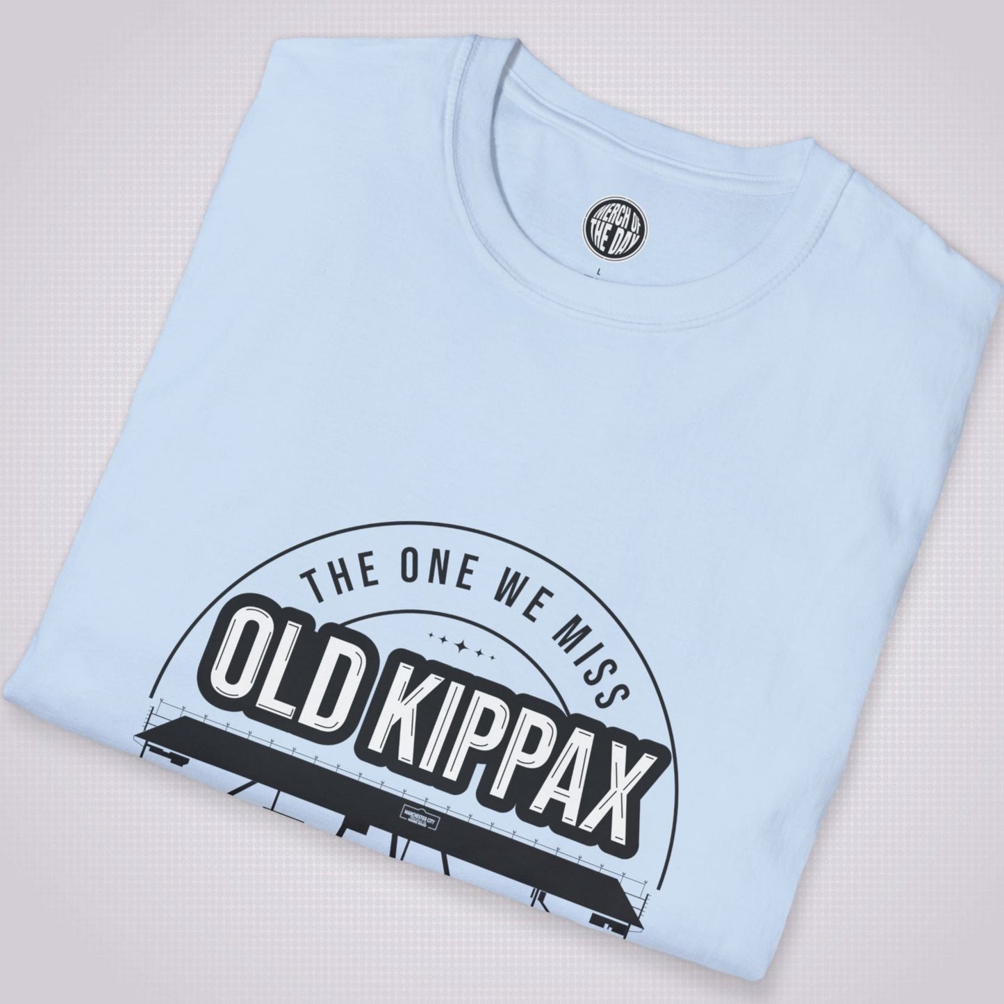 Light blue t shirt folded up and placed at a slight angle on a light grey dotted background