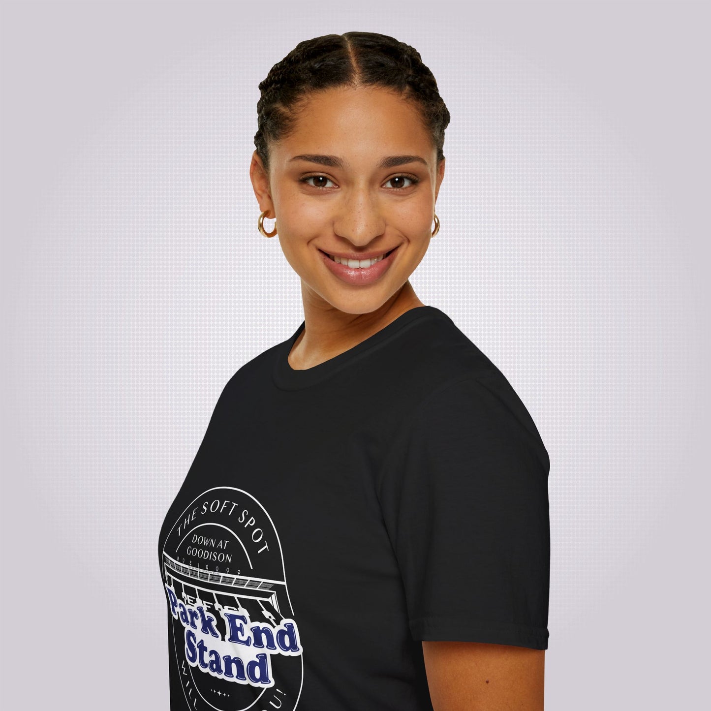 Side profile picture featuring an attractive young mixed race woman in her twenties. She is wearing the black t shirt and her body is facing the left of the screen, but her head is turned to face the camera as she smiles.