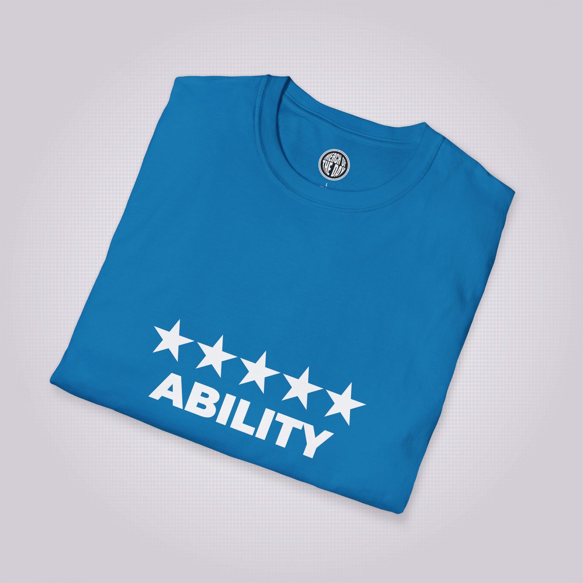 Royal blue t shirt folded and placed at a right angle and laid against a light grey dotted backdrop