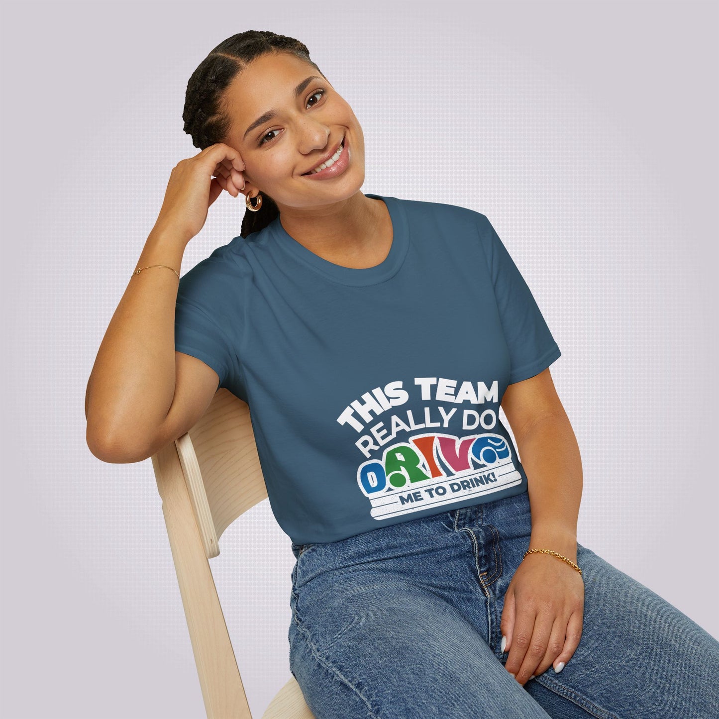 Young mixed race woman in her twenties sits on a chair leaning against her elbow she is wearing the indigo blue t shirt and jeans