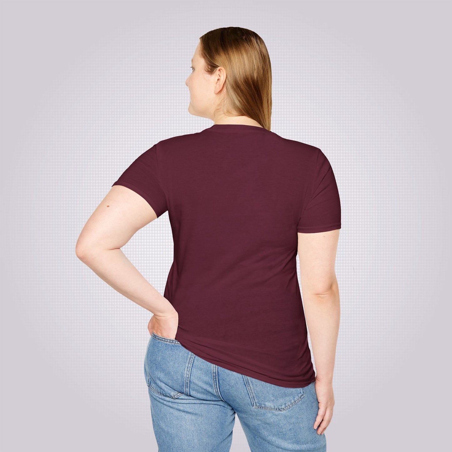 Young female model in her twenties stands with her back to the camera wearing the maroon t shirt with a pair of jeans